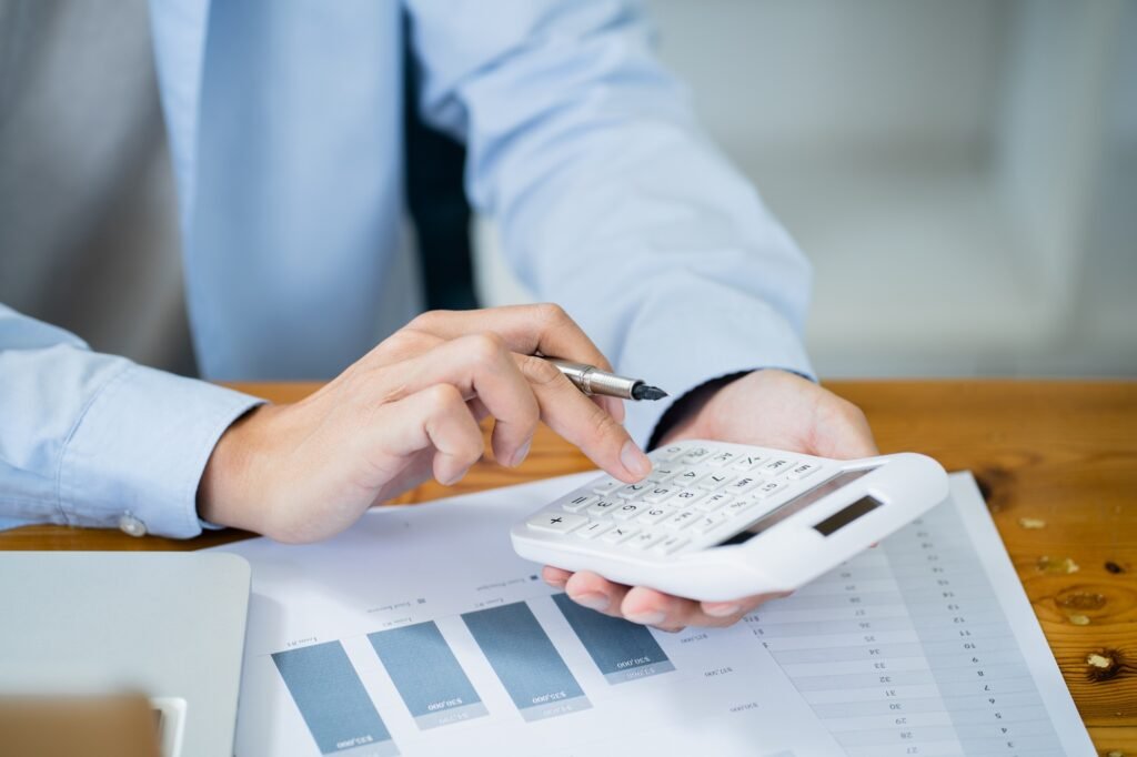 Businessman Accountant analyzing investment charts Invoice and pressing calculator buttons